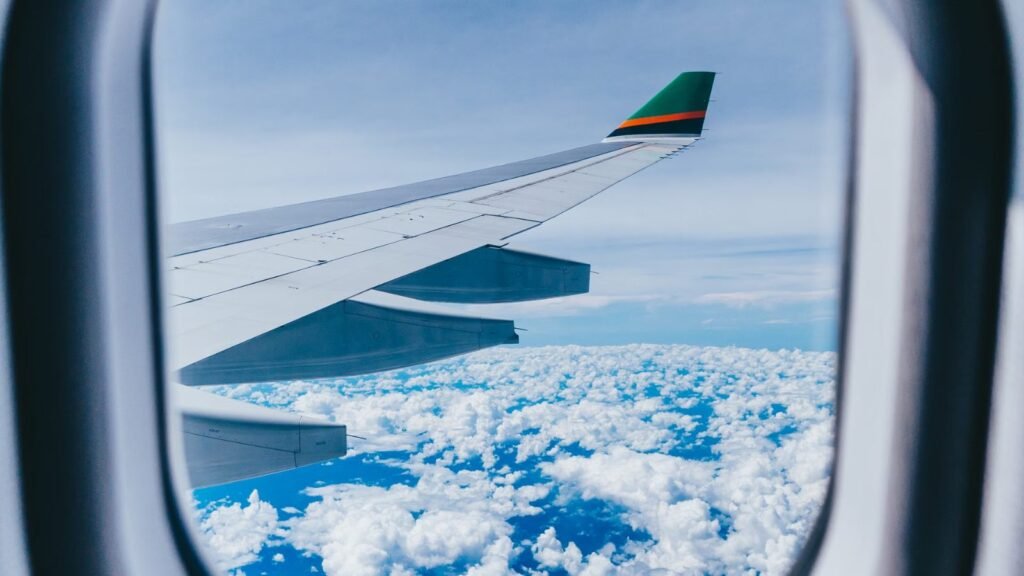 Scenic view of aircraft wing and sky seen through a plane window