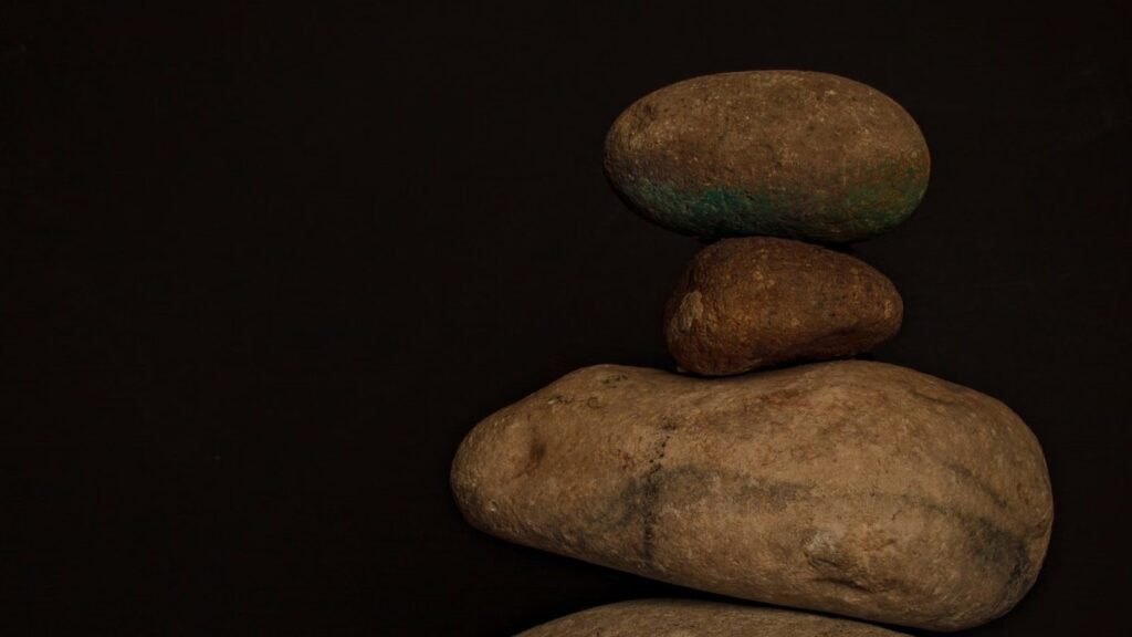 Stacked stones creating a calm minimalist composition against a dark backdrop