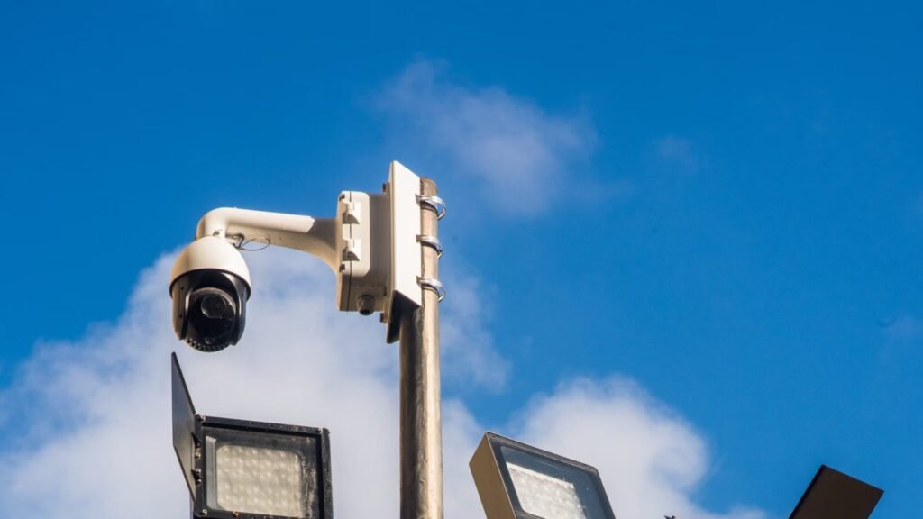 CCTV surveillance cameras mounted on a pole against a blue sky