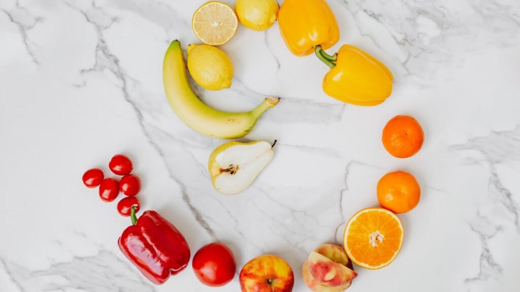 Vibrant top view of assorted fruits and vegetables arranged on a marble surface