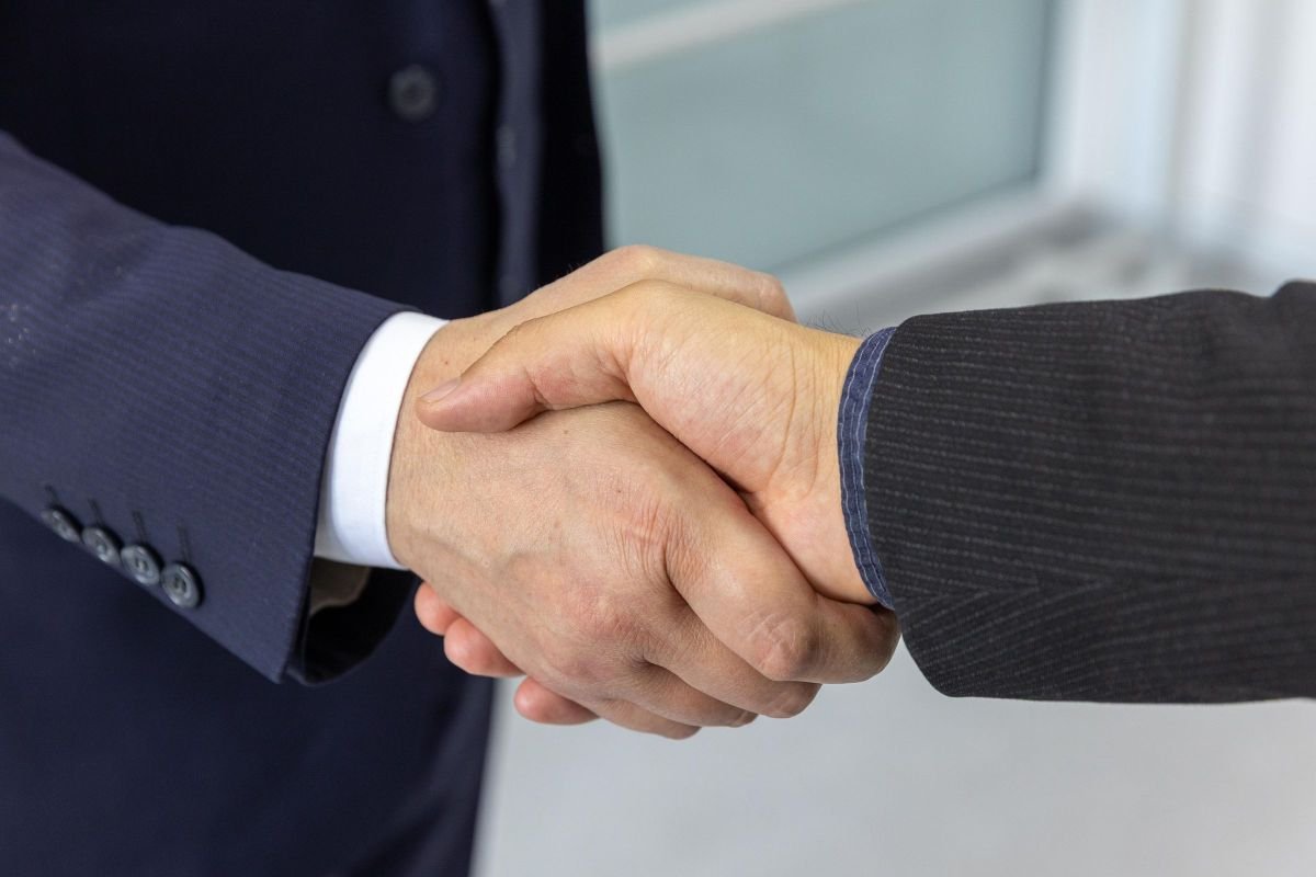 Professional handshake, representing ongoing coaching support and accountability