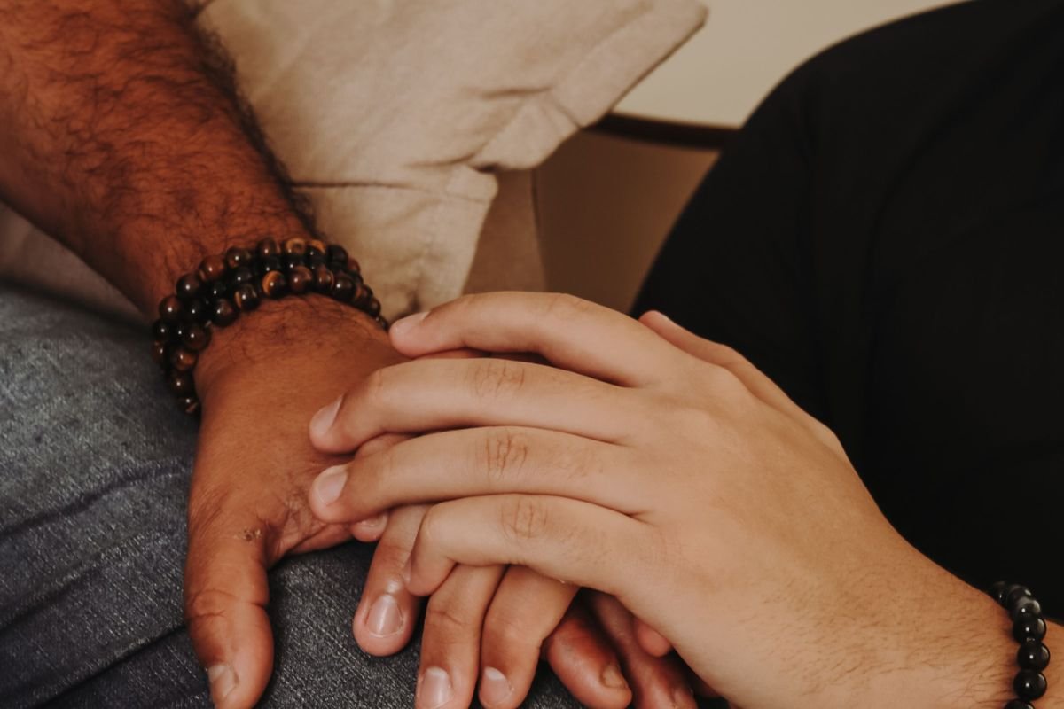A close-up of two hands holding, symbolising support and compassion