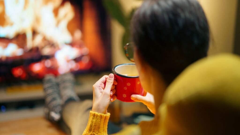 Woman relaxing with a hot beverage by the fireplace on a calm winter evening