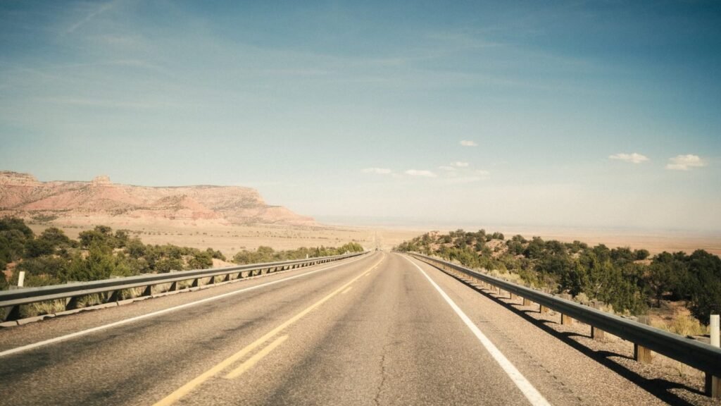 A calm open road in the desert under a blue sky