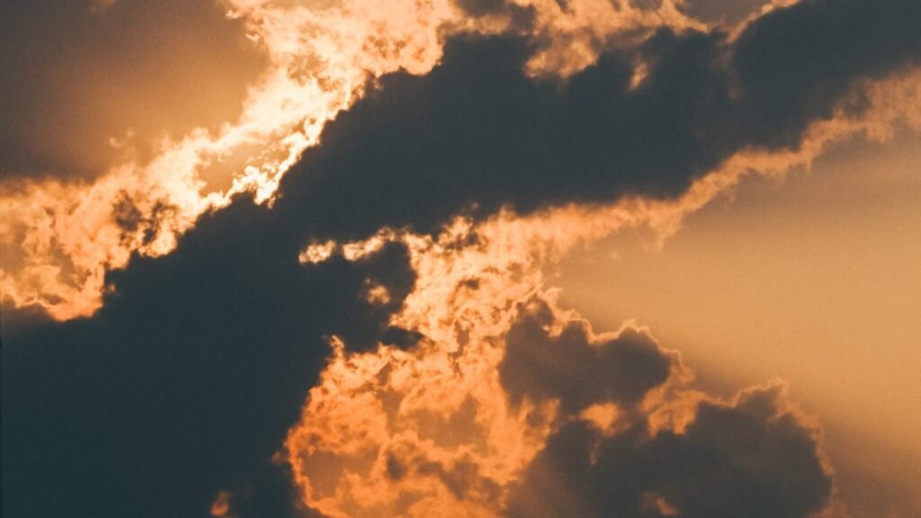 A dramatic sky with sun rays breaking through clouds at sunset