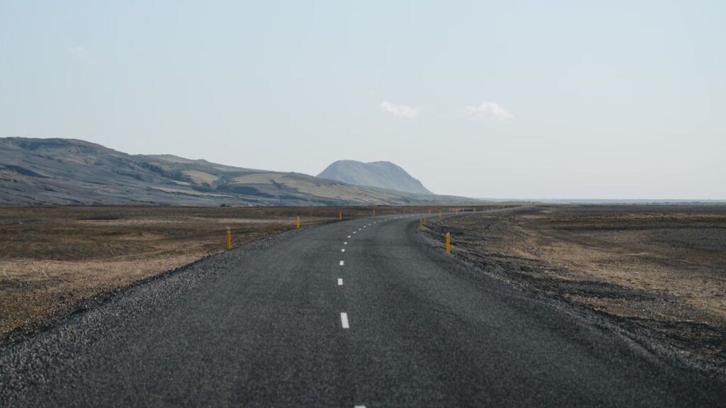 Empty highway stretching through a dramatic landscape