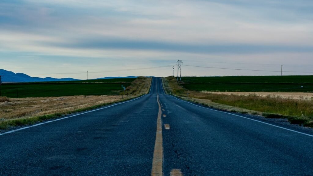 Empty road stretching through vast countryside landscape