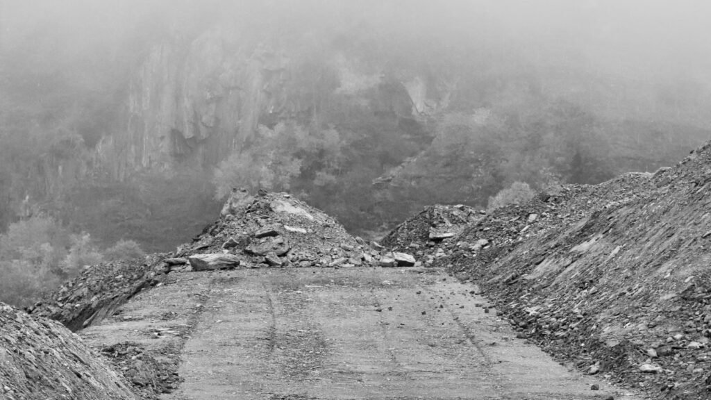 A lonely road disappearing into fog through misty mountains, symbolising uncertainty