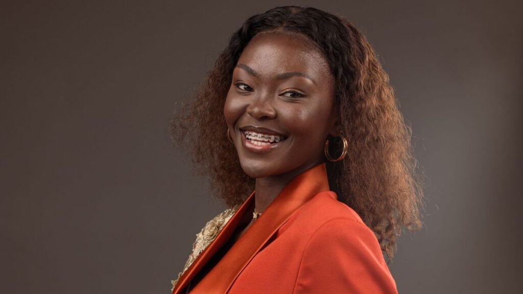 Confident woman in a vibrant orange suit, posing self-assuredly