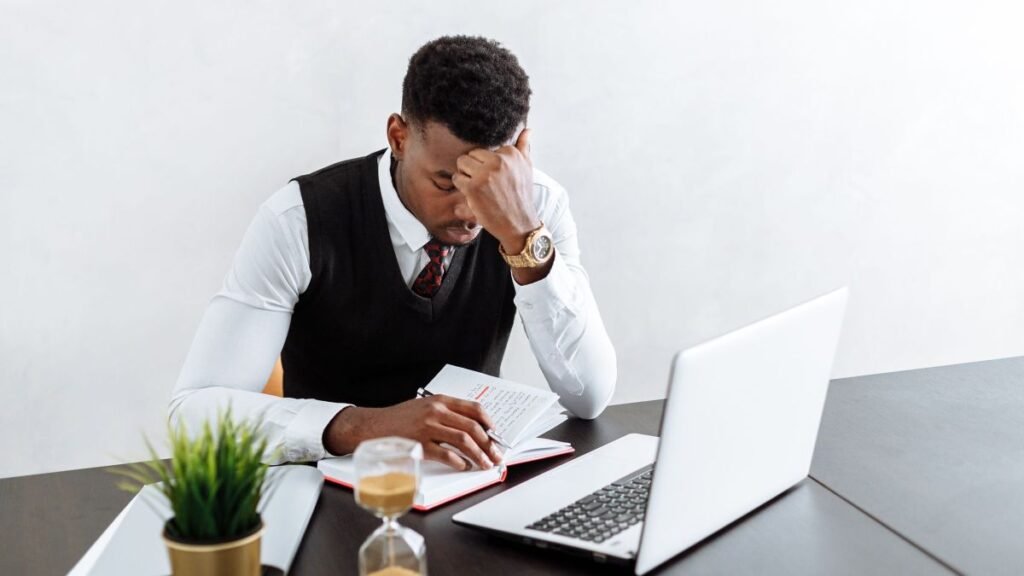Focused businessman working at his desk with a laptop and hourglass