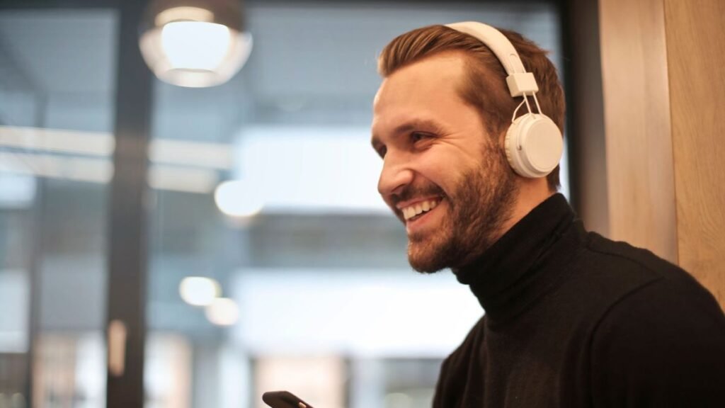 Bearded man smiling with headphones, enjoying music