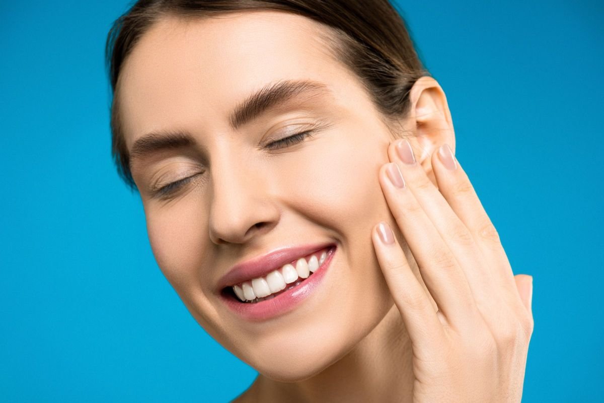 Smiling woman with eyes closed, representing calm and a positive start to a mindfulness journey