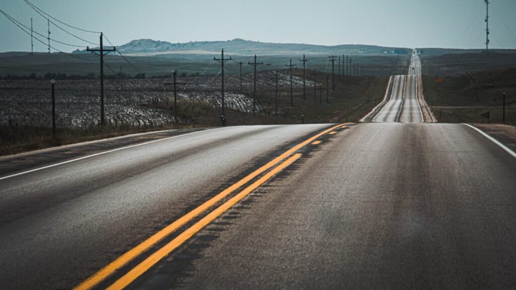 A scenic highway stretching through rolling hills under open sky