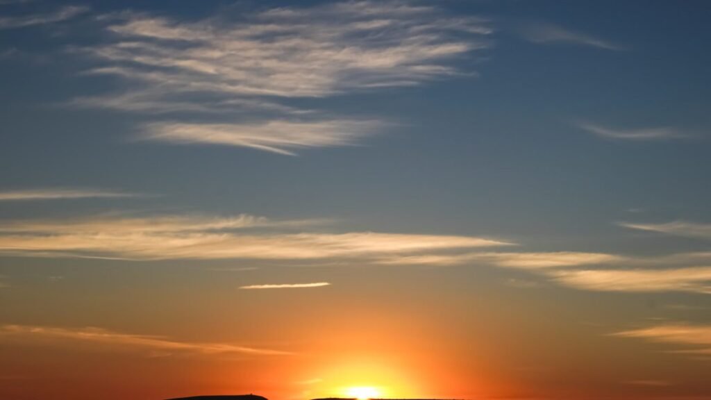 Scenic sunrise over the horizon with soft clouds