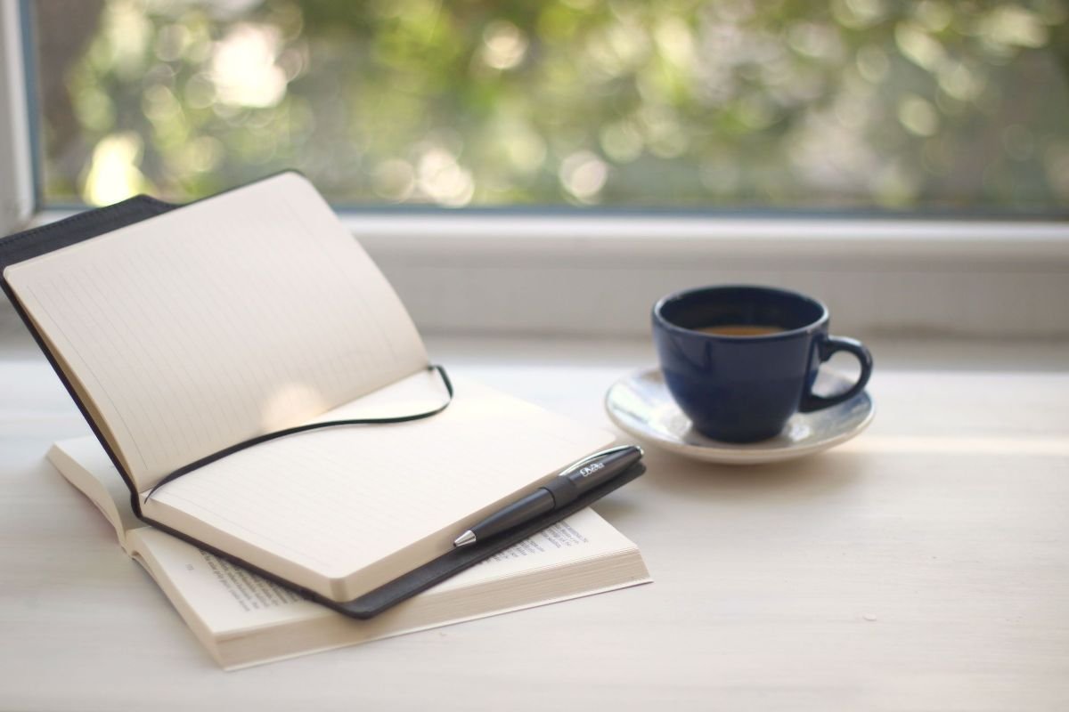 Person journaling self-confidence affirmations by a sunlit window each morning