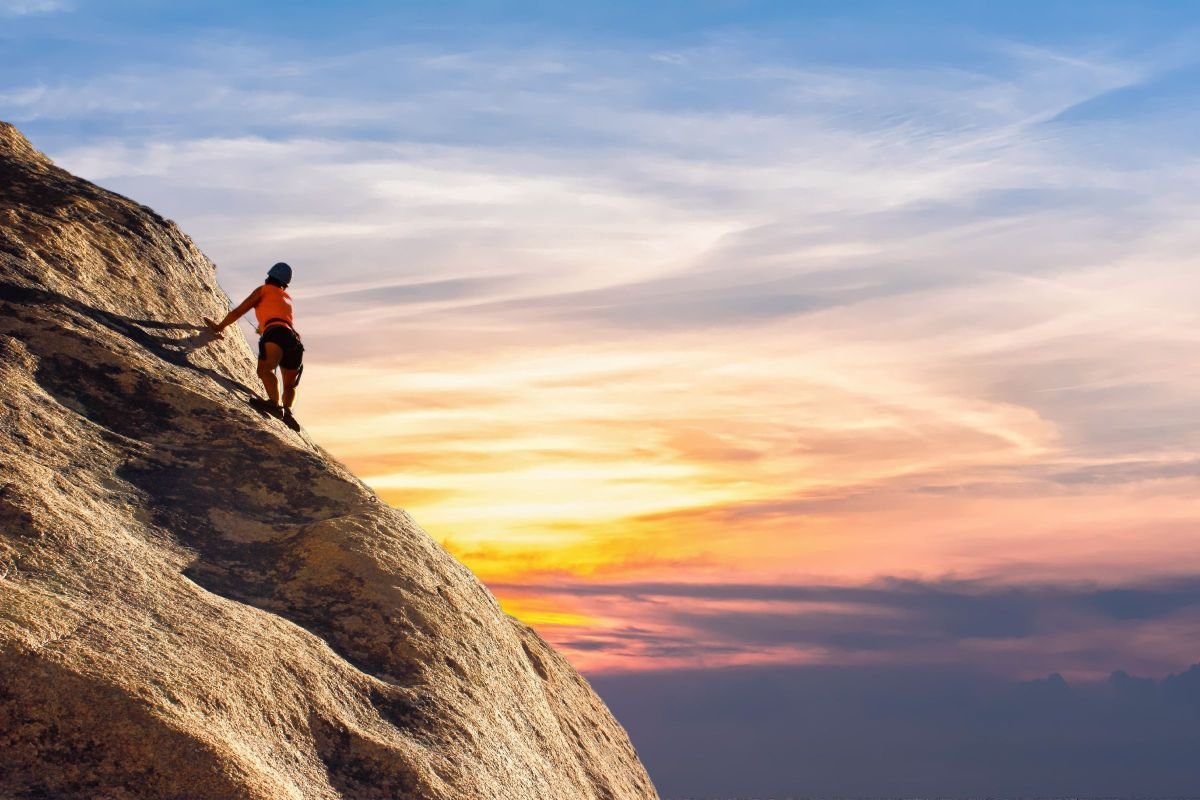 Person climbing a mountain path, symbolising overcoming challenges with self-confidence affirmations
