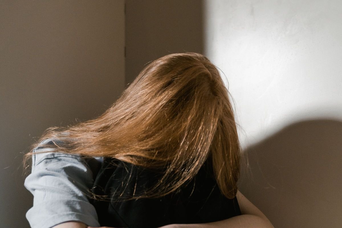 Woman sitting alone quietly, reflecting the impact of social anxiety on work life