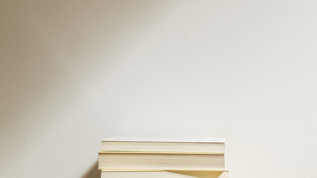 A minimalist stack of books on a wooden desk