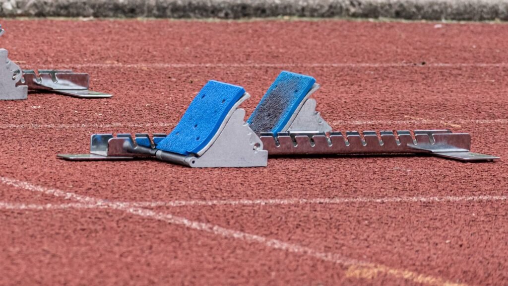 Close-up of starting blocks on a red athletics track, ready for a race