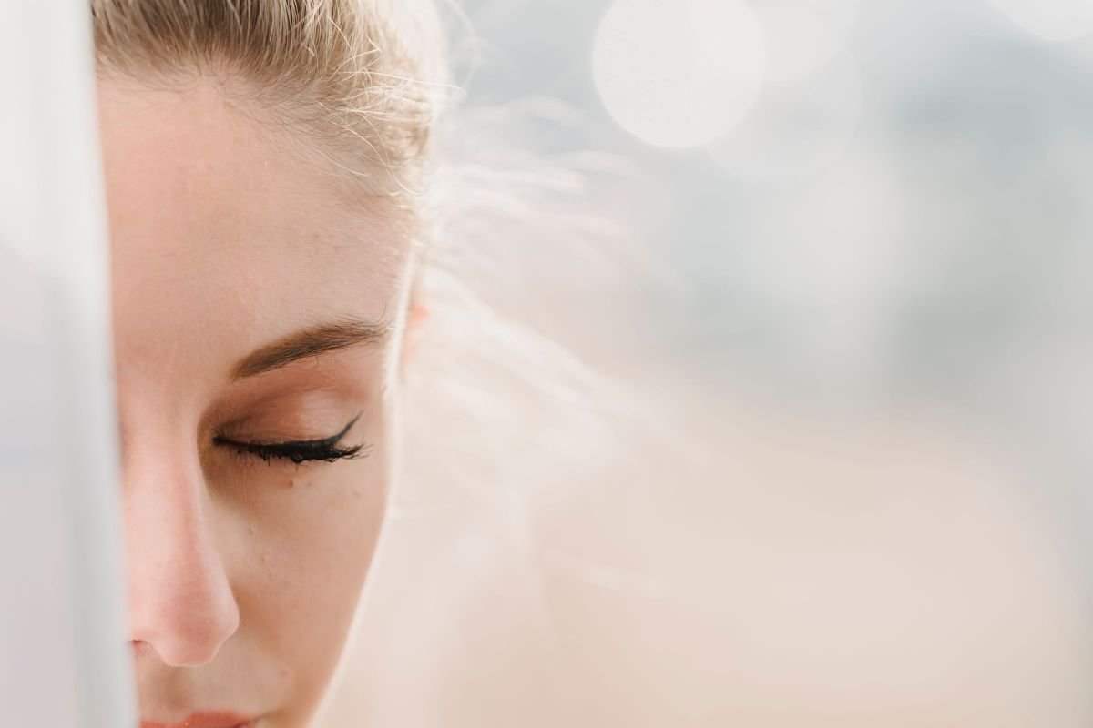 Peaceful woman meditating with closed eyes in sunny morning light
