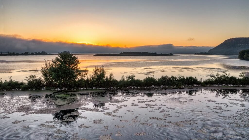 Scenic sunrise over a quiet lake horizon
