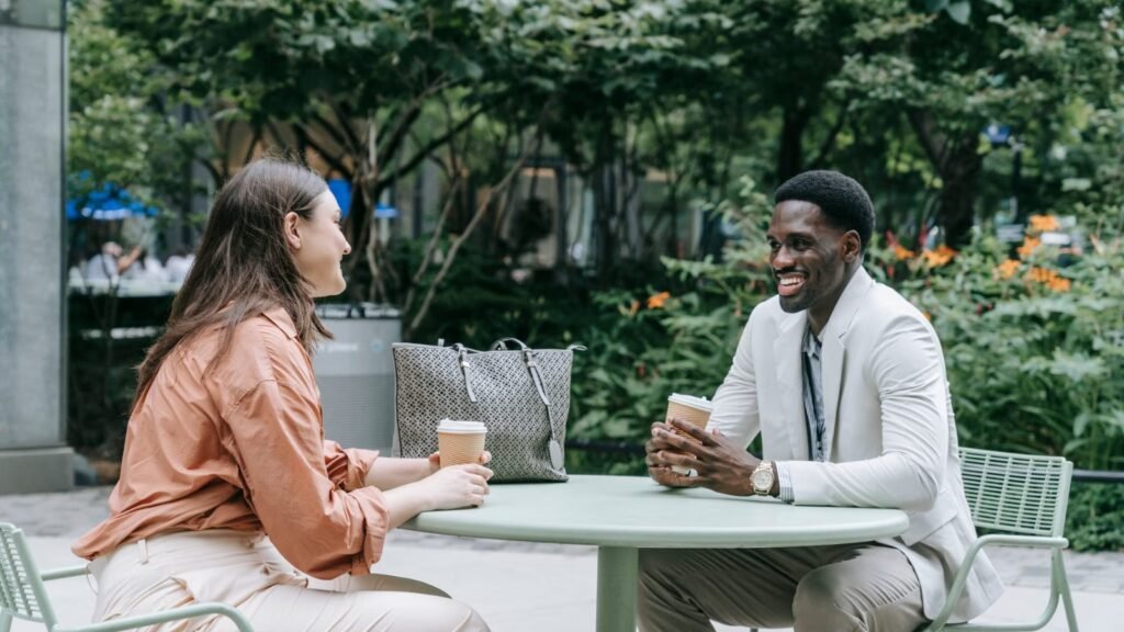 Two people talking and opening up at a cafe table outdoors