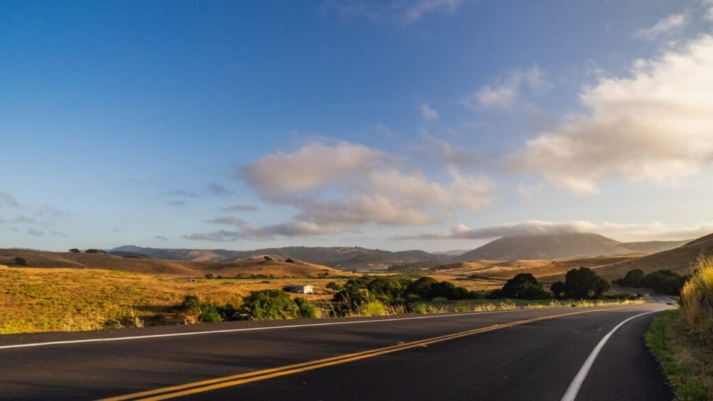 Scenic view of a winding road with golden hills captured at dawn