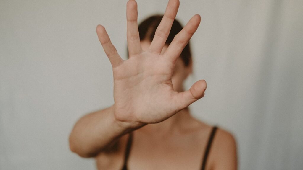 A hand extended forward in a stop gesture, setting a clear boundary